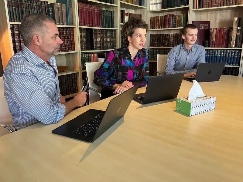 Mark Lucas, Eva Trebilco and Caleb Lucas in discussion at a table